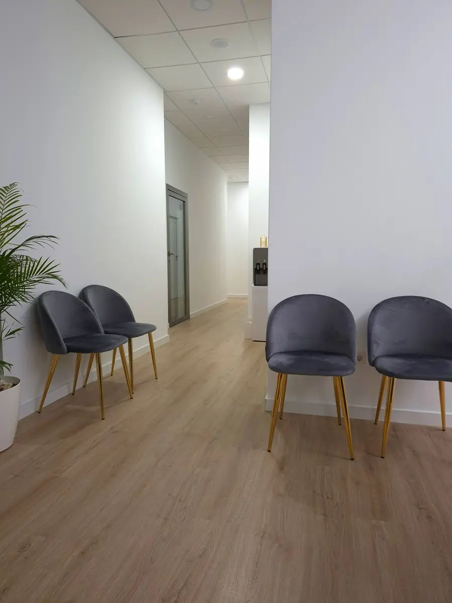 Tidy clinic waiting area with grey chairs and timber flooring